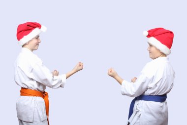 Gri bir arka plan üzerinde kapaklar Noel Baba'nın sportsmens karate rafa duruyorsun
