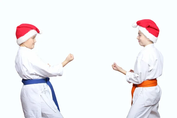 In karategi and caps of Santa Claus sportsmens are standing in rack of karate — Stock Photo, Image