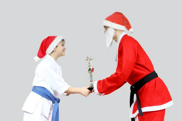 Sportsman i karategi får från jultomten med en svart bälte karate Cup — Stockfoto