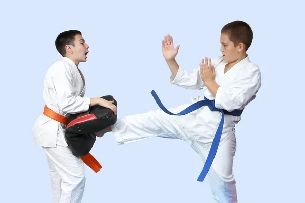 Perna de pontapé direto no simulador batendo um atleta em karategi — Fotografia de Stock