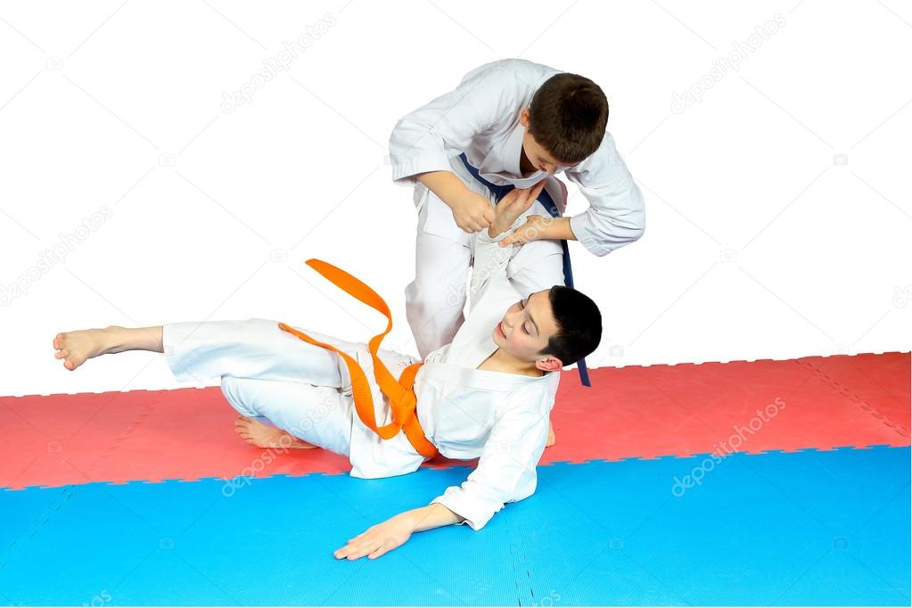 Sportsmens in judogi are training judo throws