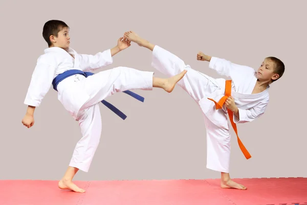 Karategi에서 남자는 매트에 발 차기를 꺾으십시오 — 스톡 사진