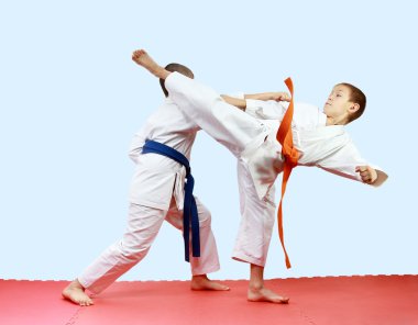 Genç sporcular darbeler bacakları ve kolları paspaslar üzerinde eğitim