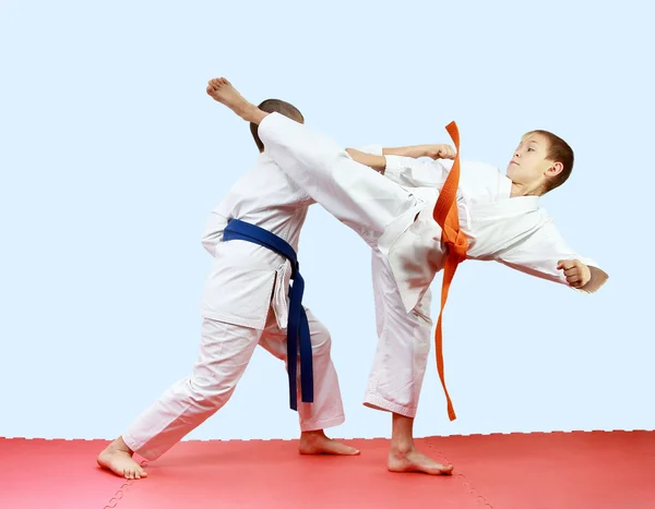 Young athletes are training blows legs and arms on the mats — Stock Photo, Image