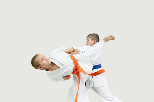 Jongens in karategi doen gepaarde oefeningen karate — Stockfoto