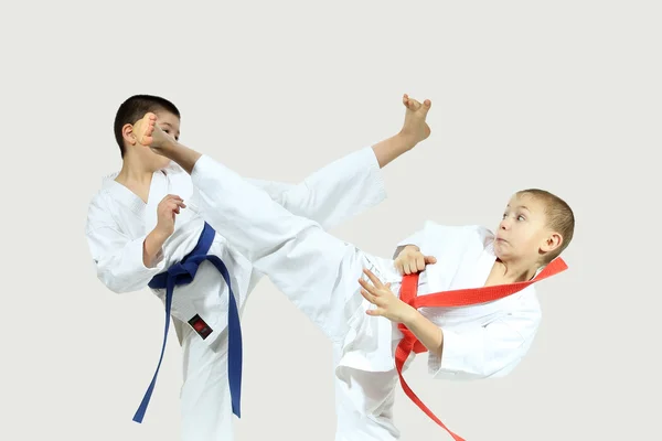 Hauts coups jambes sont battus sportifs dans karategi — Photo
