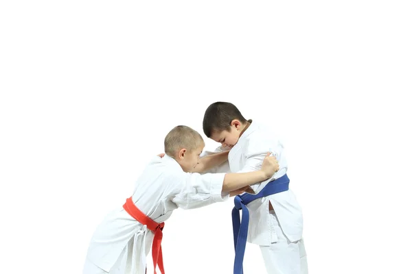 Jongen met de rode gordel zijn perfoming vangen judogi de sportman met blauwe riem — Stockfoto