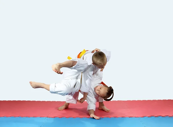 Sobre un fondo azul deportistas en karategi están entrenando lanzando —  Fotos de Stock