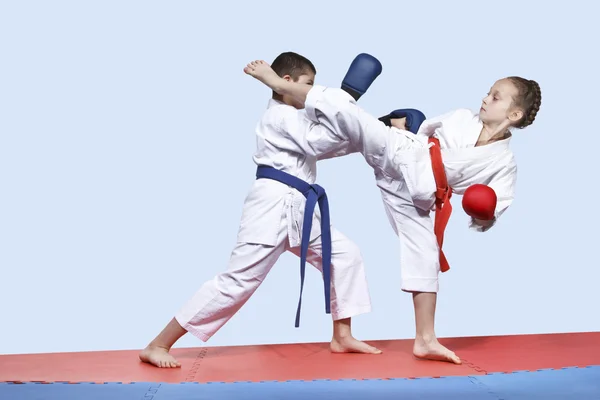 Menino e menina em karategi estão treinando exercícios pareados karatê — Fotografia de Stock