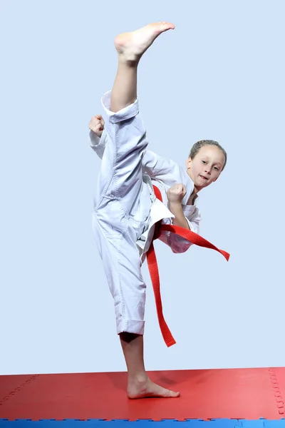 På en ljus bakgrund gör idrottskvinna roundhouse kick — Stockfoto