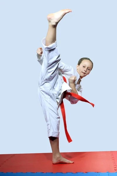 Med ett rött bälte slår idrottskvinna roundhouse kick ben — Stockfoto