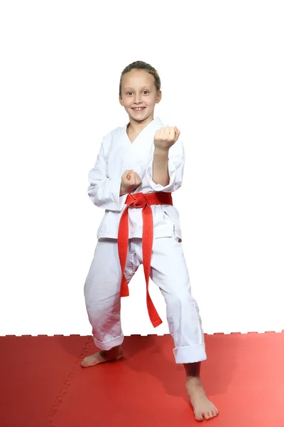 Cheerful girl stands in rack of karate — Stock Photo, Image