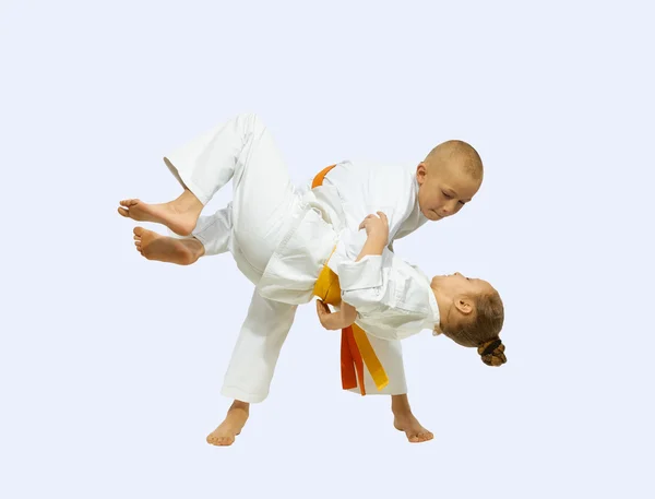 Jongen en meisje in judogi opleiding gooien — Stockfoto