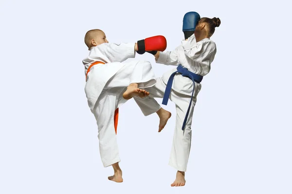 Ragazza e ragazzo in karategi scambiato colpi gambe — Foto Stock