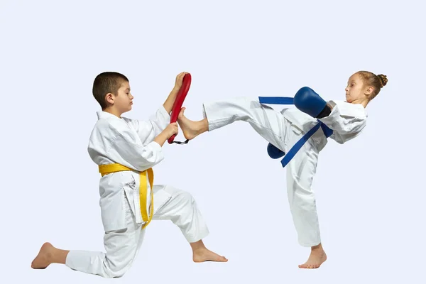 Girl and boy are training the blow mae geri on simulator — Stock Photo, Image