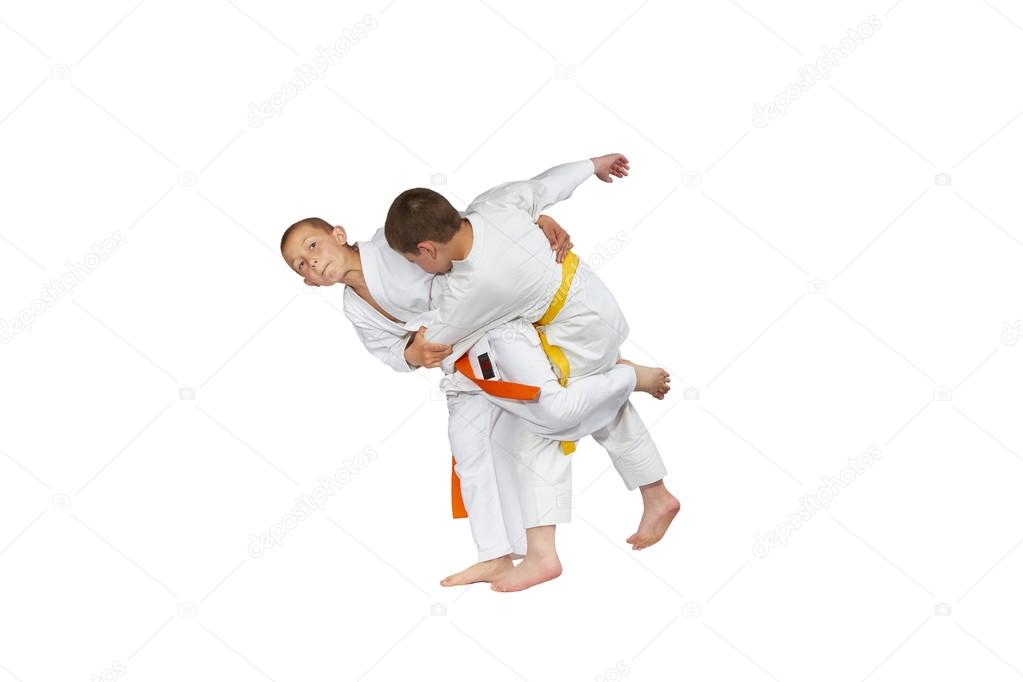 Children in judogi are training judo throws