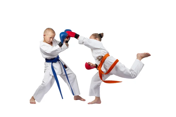 Boy and girl trains the blow gyaku-tsuki in jumping — Stock Photo, Image