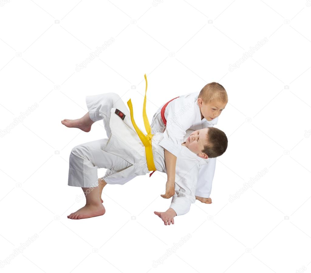 Boys do Judo throws on a white background