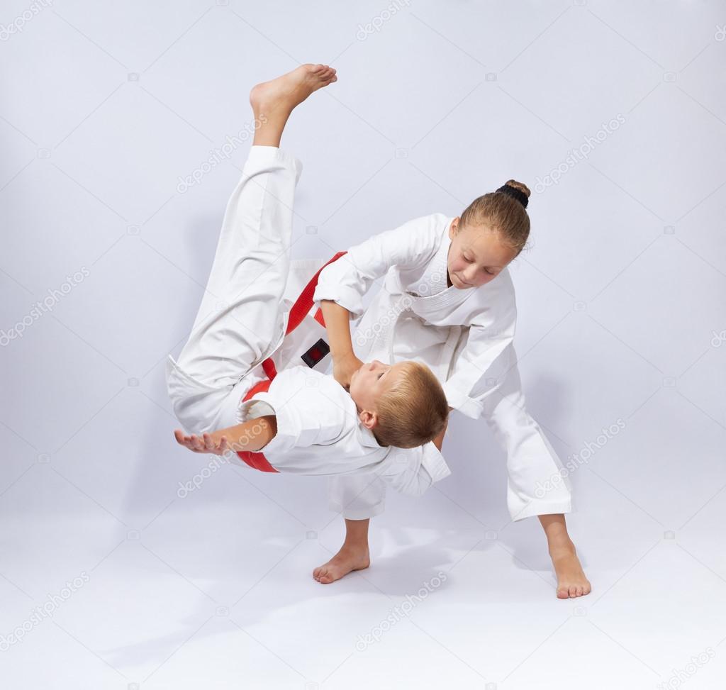 Two athletes in judogi are training throws