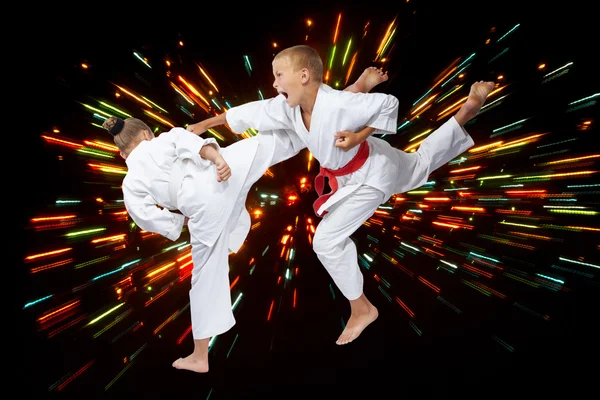 Gyaku-tsuki und mavashi geri in performing children in karategi — Stockfoto