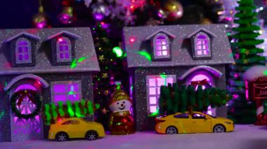 Kırmızı bir ev bir Noel köyünün arka planında dönüyor.