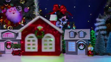 Bir Noel kasabasının arka planında, küçük kırmızı bir ev ışıklarla kaplı