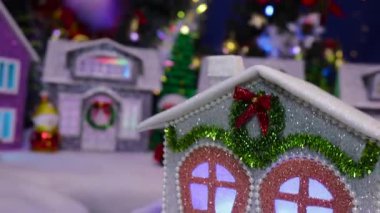 Gri bir ev dekore edilmiş bir Noel kasabasının arka planında döner.