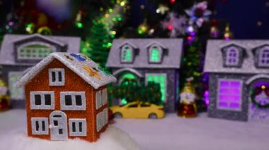 Süslü bir Noel kasabasının arka planında turuncu bir ev dönüyor