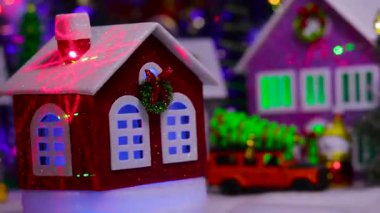 Kasabanın merkezinde küçük kırmızı bir Noel evi dönüyor.