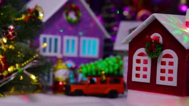 Kasabanın merkezinde küçük, parlak kırmızı bir Noel evi dönüyor.