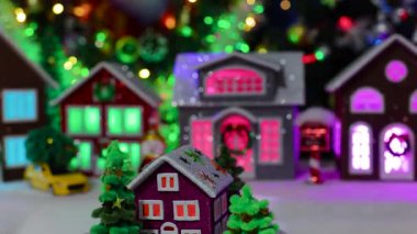 Noel ağaçlarıyla çevrili küçük, koyu pembe bir Noel evi büyük, süslü bir Noel kasabasının merkezinde dönüyor.