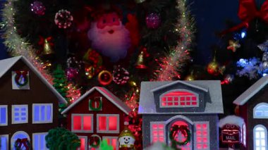 Büyük bir Noel çelenginin altında renkli evleri olan küçük bir Noel kasabası var.