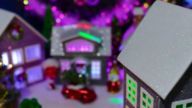Bir Noel köyünün önünde dönen gri bir evin yakın çekimi.