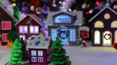 Noel ağaçlarıyla çevrili küçük, koyu pembe bir ev büyük, süslü bir Noel kasabasının ortasında dönüyor.