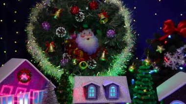 Noel kasabasının merkezinde önünde harfler olan gri bir ev var.