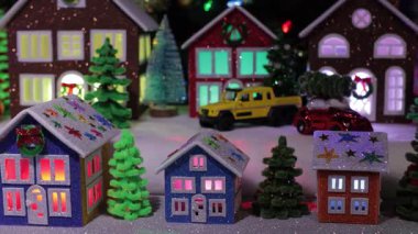 Büyük evlerin önünde küçük evler ve küçük Noel ağaçları olan bir Noel kasabası.