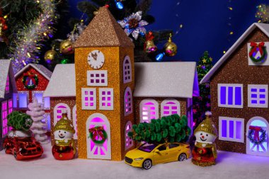 Merkezinde arabalar ve kardan adamlar olan bir Noel köyü.