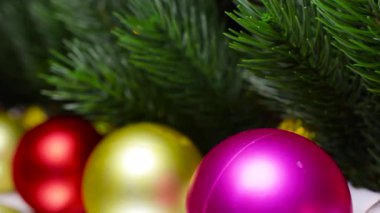 Noel ağacı dallarının altında çok renkli toplar Noel evinin yanında.