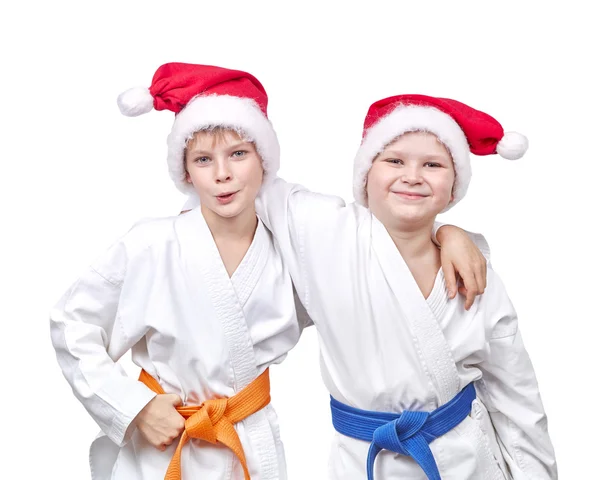 Alegre amigos abrazándose en un kimono y usando sombrero de Santa — Foto de Stock