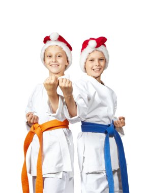Two athletes in caps of Santa Claus standing in rack of karate clipart