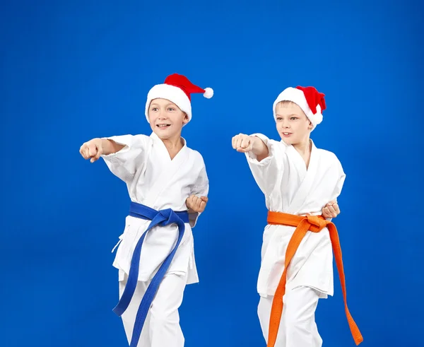 In caps of Santa Claus sportsmens are beating blows hands — Stock Photo, Image