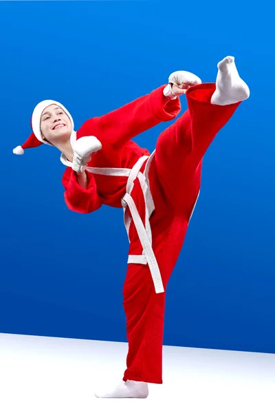 Deportiva vestida como Santa Claus golpea una patada en la pierna — Foto de Stock