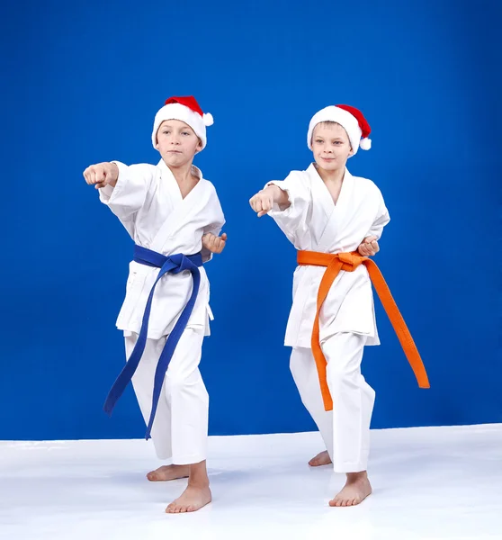 Two athletes in caps of Santa Claus beats punch hand — Stock Photo, Image