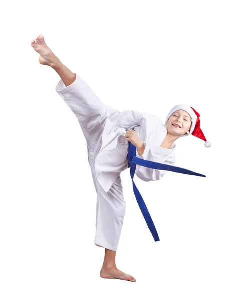 Junge mit Weihnachtsmannmütze schlägt ein hohes Kick-Bein — Stockfoto
