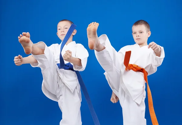Em karategi sportsmens bate sopra perna — Fotografia de Stock