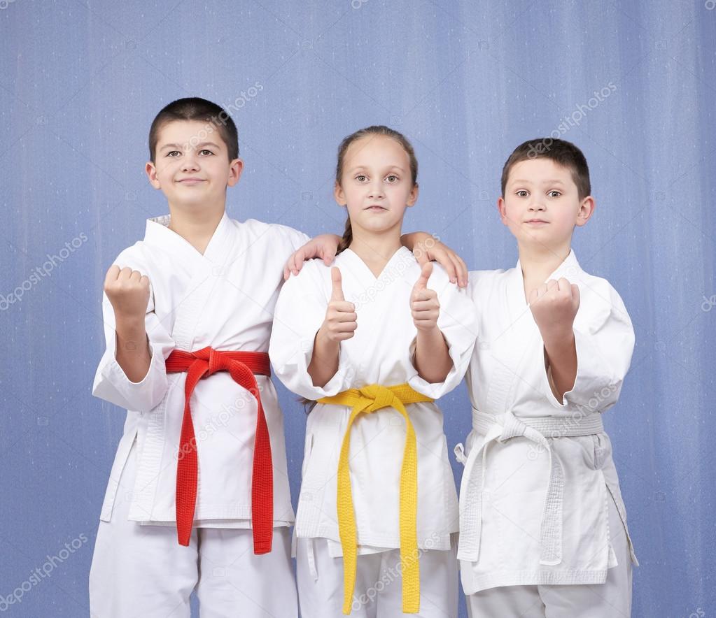 Boy and girl standing in rack of karate and showing the finger super