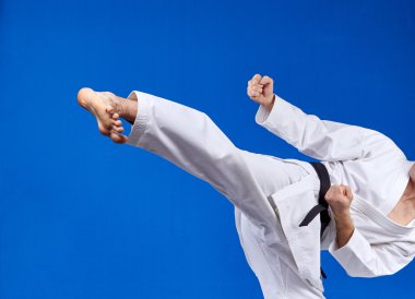 Üzerinde mavi bir arka plan atlet tekme atıyor