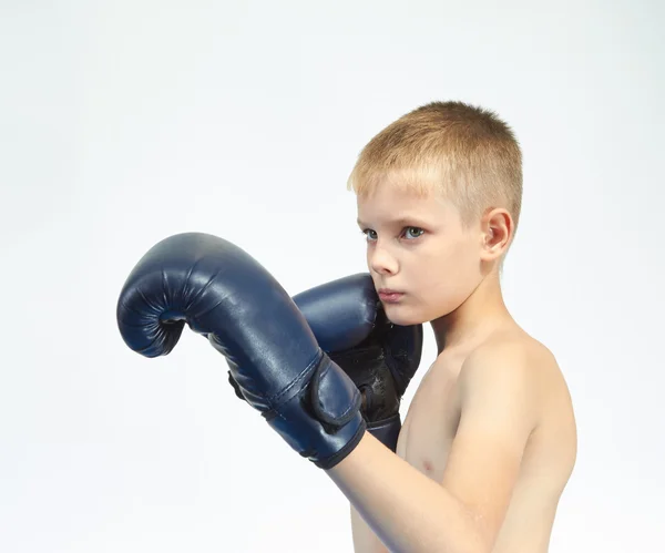 С боксерскими перчатками на руках маленький спортсмен на светлом фоне — стоковое фото