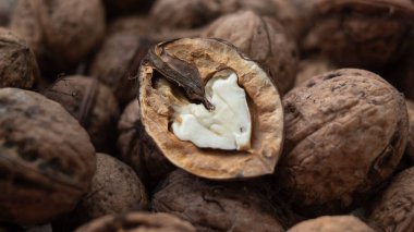 Yarım cevizli bir yakın plan, içinde kalp şeklinde bir ceviz parçası ortaya çıkıyor..