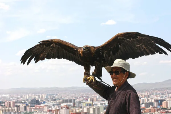 Ulaanbaatar, Moğolistan - 20 Temmuz 2019 Ulaanbaatar, Moğolistan 'da kartal. Büyük şapkalı turist fotoğraf çekmek için bir kuş tutuyor.
